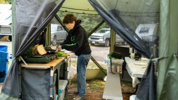 woman cooking on camp kitchen in screen room