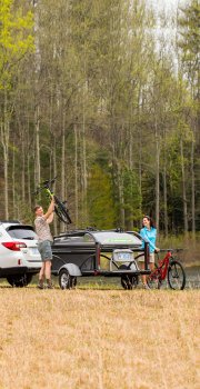 men grabbing bike from bike rack Go Camper
